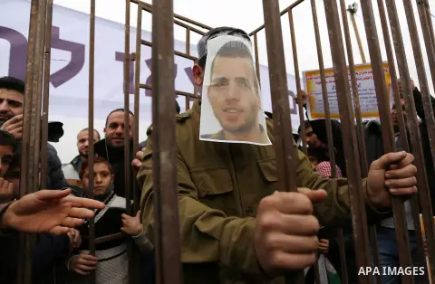 A Palestinian man playing the role of Israeli soldier Oron Shaul stands in a mock jail during a rally in solidarity with Palestinian prisoners held in Israeli jails, in the northern Gaza Strip December 29, 2017. Photo by...