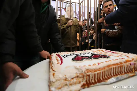 A Palestinian man playing the role of Israeli soldier Oron Shaul is seen in a mock jail as he tries to participate in a birthday party, during a rally in solidarity with Palestinian prisoners held in Israeli jails, in th...
