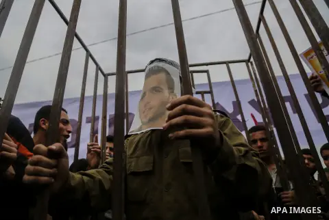 A Palestinian man playing the role of Israeli soldier Oron Shaul stands in a mock jail during a rally in solidarity with Palestinian prisoners held in Israeli jails, in the northern Gaza Strip December 29, 2017. Photo by...