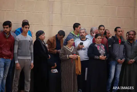 Egyptians stand near the site of a gun attack on Mar Mina church in Helwan district on the outskirts of Cairo, on December 29, 2017. A gunman opened fire on a church, killing at least nine people before policemen shot hi...