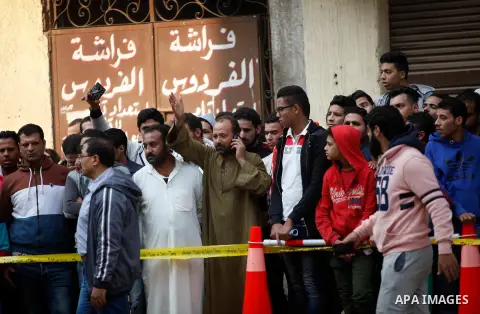 Egyptians stand near the site of a gun attack on Mar Mina church in Helwan district on the outskirts of Cairo, on December 29, 2017. A gunman opened fire on a church, killing at least nine people before policemen shot hi...