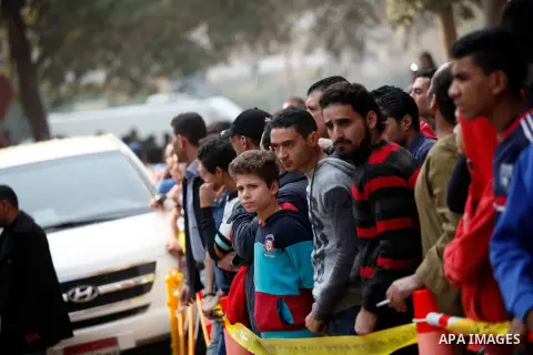 Egyptians stand near the site of a gun attack on Mar Mina church in Helwan district on the outskirts of Cairo, on December 29, 2017. A gunman opened fire on a church, killing at least nine people before policemen shot hi...
