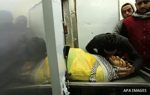 Relatives of Palestinian Jamal Mesleh, 21, who died of his injuries during clashes with Israeli security forces on Friday mourn over his body at a hospital morgue, in Dair Al Balah in the central Gaza Strip December 30,...