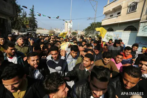 Mourners carry the body of Palestinian Jamal Mesleh, 21, who died of his injuries during clashes with Israeli security forces on Friday, during his funeral in the al-Maghazi refugee camp in the central Gaza Strip Decembe...