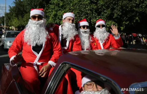 Palestinians dressed as Santa Claus ride a red car to welcome the new year, in the streets of Gaza City, New Year's Eve revellers on December 31, 2017. Photo by Ashraf Amra