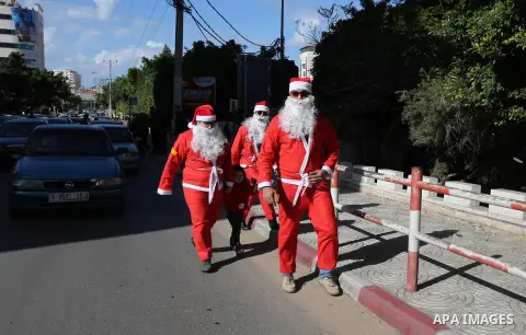 Palestinians dressed as Santa Claus celebrate to welcome the new year, in the streets of Gaza City, New Year's Eve revellers on December 31, 2017. Photo by Ashraf Amra