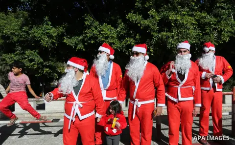 Palestinians dressed as Santa Claus celebrate to welcome the new year, in the streets of Gaza City, New Year's Eve revellers on December 31, 2017. Photo by Ashraf Amra
