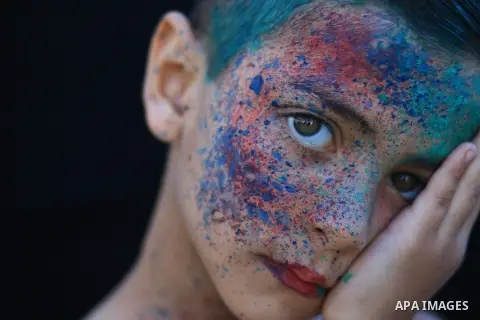 A portrait of a boy with colored face. Photo by Sanad Ltefa