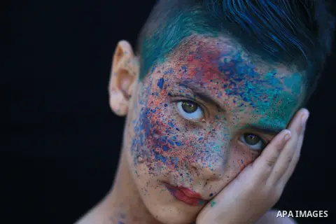 A portrait of a boy with colored face. Photo by Sanad Ltefa