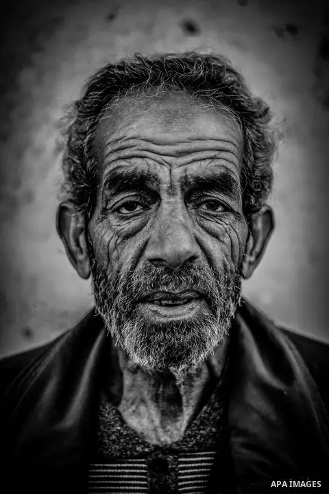 A portrait of an elderly man with wrinkled face and upset look. Photo by Sanad Ltefa