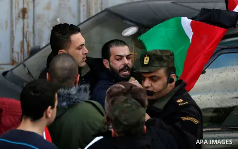 Palestinian policemen push away protesters from the convoy of Jerusalem's Greek Orthodox patriarch Theophilos III in the West Bank town of Bethlehem on January 6, 2018 ahead of a Christmas service according to the Easter...