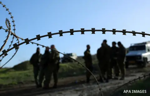 Israeli security forces stand guard during dredging Palestinian lands at the village of Burin near the West Bank city of Nablus, on January 14, 2018. Photo by Shadi Jarar'ah
