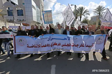 Palestinians hold placards during a protest against the security coordination in Gaza City, on January 16, 2018. Photo by Ashraf Amra