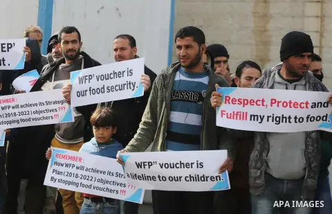 Palestinians hold banners during a protest against aid cut, in front of United Nations Development Programme office (UNDP), in Gaza City January 17, 2018. Photo by Mohammed Asad