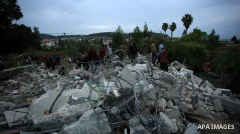 Palestinians stand on the rubble of the house of Palestinian gunman Ahmed Jarrar following an Israeli raid in the occupied West Bank, after it was demolished overnight on January 18, 2018 in Jenin. A Palestinian was kill...