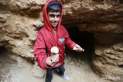 A Palestinian boy holds pottery fragments at a freshly-discovered cemetery which was found by Abdelkarim al-Kafarna in his backyard in town of Beit Hanoun, in the northern Gaza strip on January 27, 2018. Experts said the...