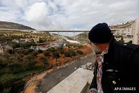 A Palestinian man watchs as Israeli machineries demolish an under-construction Palestinian residential building in the West Bank town of Biet Jala, near Bethlehem January 29, 2018. Photo by Wisam Hashlamoun