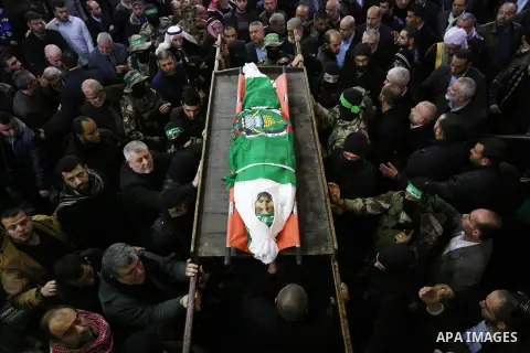 Palestinian militants from the Ezzedine al-Qassam Brigades, the armed wing of the Hamas movement carry the body of Hamas senior leader Imad al-Alami during his funeral at the al-Omari mosque in Gaza City on January 30, 2...