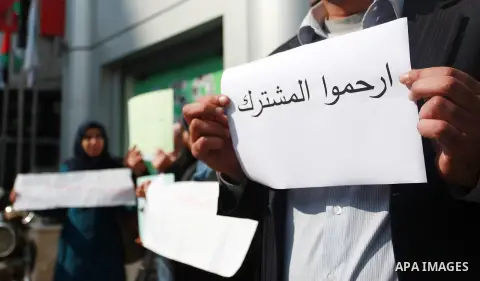 Palestinians hold banners during a protest against Jawwal's decision to add 16% VAT to its customers in the Gaza Strip in Gaza city on January 31, 2018. Photo by Mahmoud Ajour