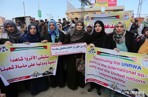 Palestinian women hold placards in a protest against the US move to freeze funding for the UN agency for Palestinian refugees on January 31, 2018 at the al-Nusairat refugee camp, in central Gaza Strip. On January 16, Was...