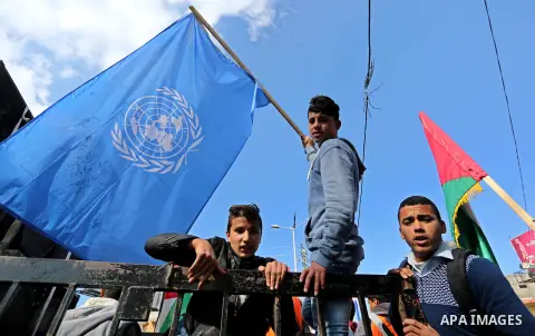Palestinian school students shout slogans and hold placards in a protest against the US move to freeze funding for the UN agency for Palestinian refugees on January 31, 2018 at the al-Nusairat refugee camp, in central Ga...