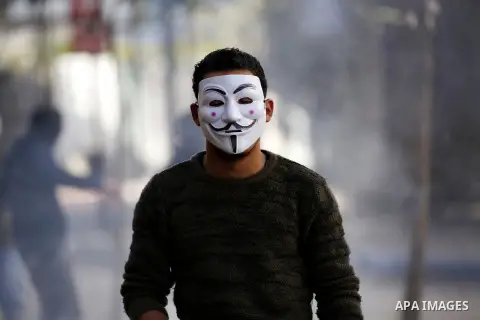 A masked Palestinian protester looks on during clashes with Israeli security forces in the West Bank city of Hebron on February 2, 2018 2018 as demonstrations continue over the US president's controversial recognition of...