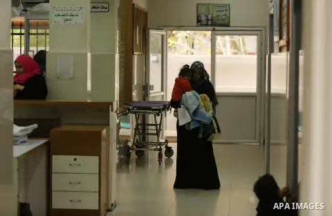 The Palestinian child is held by his mother in Dora hospital in Gaza City after it stopped its services on February 11, 2018 after it ran out of fuel. Seven medical centers in Gaza have stopped services due to lack of fu...