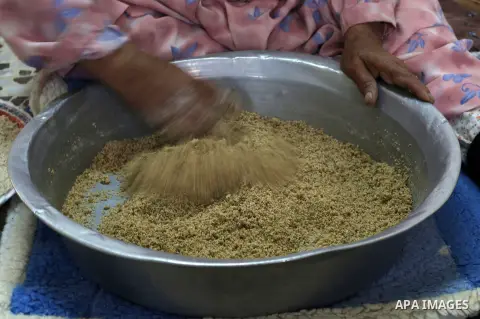 A Palestinian woman prepares fresh couscous, in the West Bank city of Nablus on February 15, 2018. Virgin Atlantic, a British airline has removed the word “Palestinian” from the name of a couscous grain salad on its in-f...