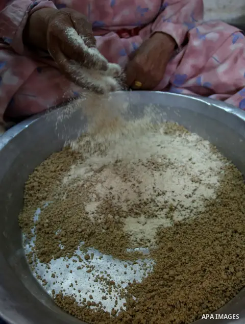 A Palestinian woman prepares fresh couscous, in the West Bank city of Nablus on February 15, 2018. Virgin Atlantic, a British airline has removed the word “Palestinian” from the name of a couscous grain salad on its in-f...