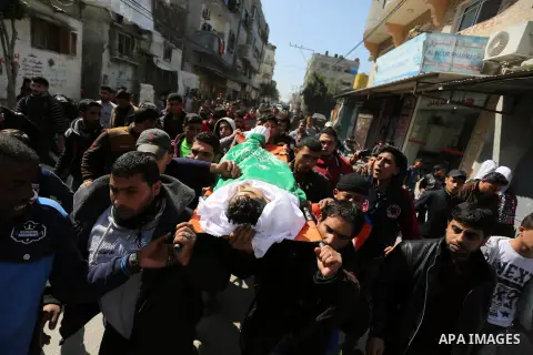 Mourners carry the body of Palestinian Ahmed Ebu Helou, 19, who died of his injuries after Israeli security forces shot him during clashes against US decision to recognize Jerusalem as Israel's capital, during his funera...