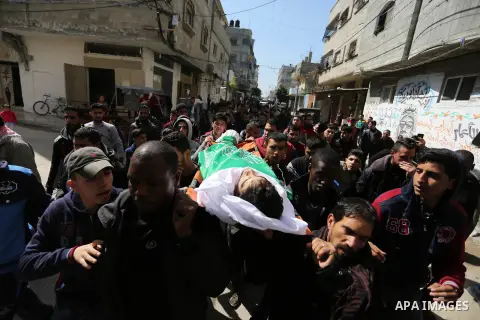 Mourners carry the body of Palestinian Ahmed Ebu Helou, 19, who died of his injuries after Israeli security forces shot him during clashes against US decision to recognize Jerusalem as Israel's capital, during his funera...