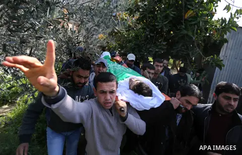 Mourners carry the body of Palestinian Ahmed Ebu Helou, 19, who died of his injuries after Israeli security forces shot him during clashes against US decision to recognize Jerusalem as Israel's capital, during his funera...