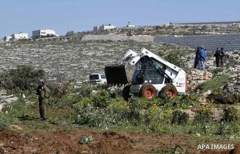 Israeli security forces stand guard as an Israeli machinery removes trees near a Jewish settlement in Hebron, in the occupied West Bank February 21, 2018. Photo by Wisam Hashlamoun
