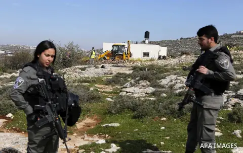 Israeli security forces stand guard as an Israeli machinery removes trees near a Jewish settlement in Hebron, in the occupied West Bank February 21, 2018. Photo by Wisam Hashlamoun