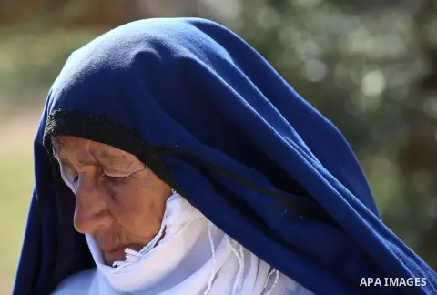 An elderly Palestinian woman Sobha Kassab 77, wears a traditional cloak or "Abaya" outside her house in the West Bank village of Qaryut, near Nablus on February 21, 2018. Decades ago, the cloack or "Abaya" was common for...