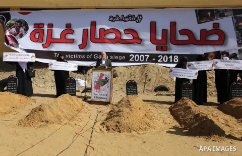 Palestinian women hold banners during a protest against the siege on the Gaza Strip in Gaza City on February 25, 2018. Israel has maintained a siege on Gaza for a decade which it says is necessary to limit Hamas, the Isl...