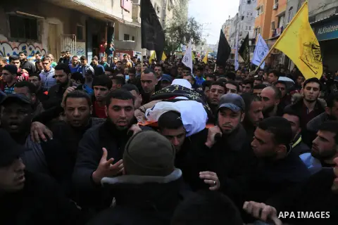 Palestinian mourners carry the body of a member of Palestinian Al-Quds Brigades militant Ibrahim Farhat, 29, who was died yesterday in an explosion during his funeral in Beit lahia in the northern Gaza Strip on March 11,...