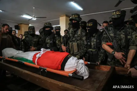 Palestinian militants from the Al-Quds Brigades, the armed wing of the Islamic Jihad movement mourn over the body of their comrade Ibrahim Farhat, 29, who was died yesterday in an explosion during his funeral in Beit lah...