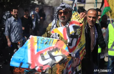 Palestinians burn an Israeli, British and U.S. flags during a protest to show solidarity with Palestinian prisoners held in Israeli jails, in front of Red cross office in Gaza city on March 12, 2018. Photo by Mahmoud Ajo...