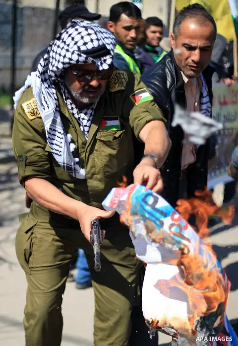 Palestinians burn an Israeli, British and U.S. flags during a protest to show solidarity with Palestinian prisoners held in Israeli jails, in front of Red cross office in Gaza city on March 12, 2018. Photo by Mahmoud Ajo...