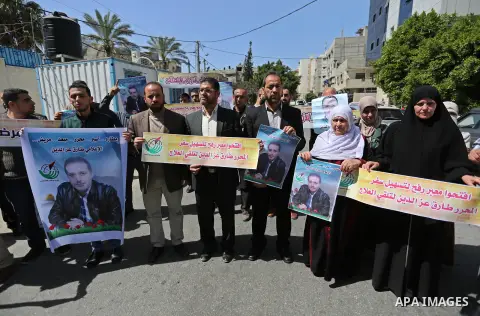 Palestinians hold placards during a protest to show solidarity with Palestinian Free prisoner Tariq Ezz al-Deen to demand his right to receive treatment abroad, in front of the high commissioner for human rights headquar...