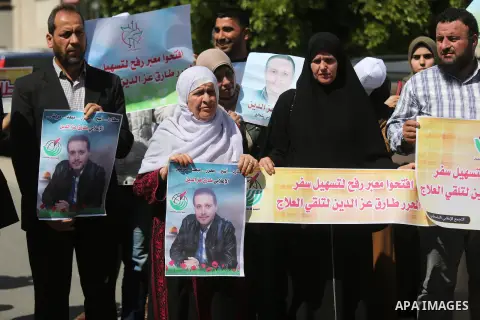 Palestinians hold placards during a protest to show solidarity with Palestinian Free prisoner Tariq Ezz al-Deen to demand his right to receive treatment abroad, in front of the high commissioner for human rights headquar...
