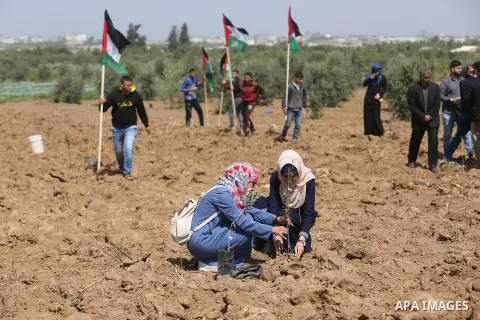 Palestinians plant during a protest ahead of the Land Day, near the border with Israel in the eastern Gaza Strip March 20, 2018. Photo by Ashraf Amra