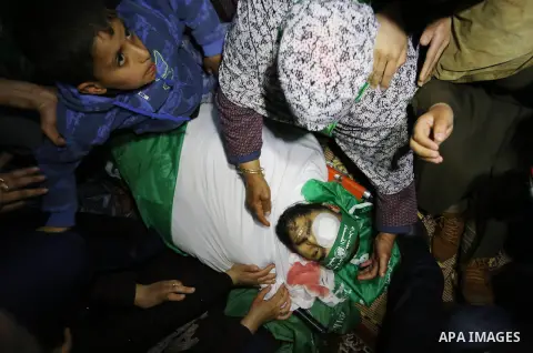 Relatives of Palestinian Ziyad Al-hawajri, react as mourners carry his body out of the family house during his funeral in Nuseirat, central Gaza Strip, Thursday, March 22, 2018. Al-hawajri, is one of the two members of H...