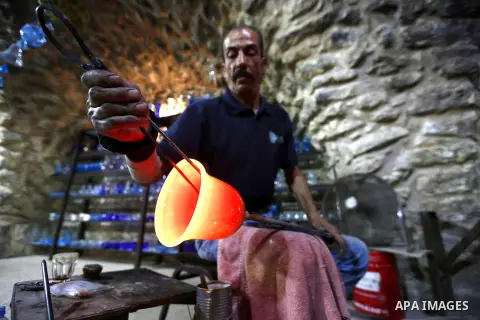 A Palestinian Yaacqoub al-Natsheh, professional glassblower who has been forming glass for over 40 years, works at his new workshop near the Ibrahimi Mosque, in the West Bank city of Hebron, March 25, 2018. Photo by Wisa...