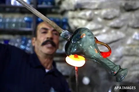 A Palestinian Yaacqoub al-Natsheh, professional glassblower who has been forming glass for over 40 years, works at his new workshop near the Ibrahimi Mosque, in the West Bank city of Hebron, March 25, 2018. Photo by Wisa...
