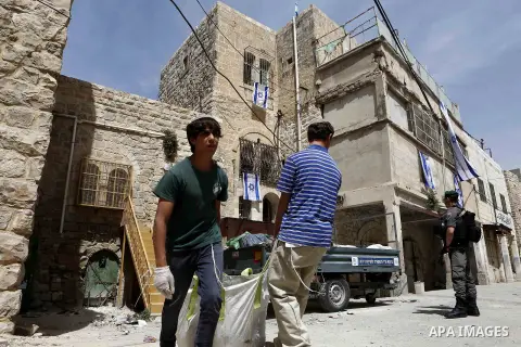 Israeli settlers prepare a Palestinian house after it was occupied by settlers the previous night near the Ibrahimi Mosque, or the Tomb of the Patriarch, in the West Bank town of Hebron on March 27, 2018. Photo by Wisam...