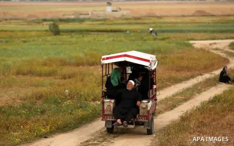 Palestinians walk and drive near the Gaza-Israel border on the outskirts of Khan Yunis in the southern Gaza Strip on March 28, 2018. Protesters plan to call for the right of Palestinian refugees across the Middle East to...