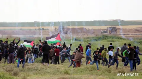 Palestinians react from tear gas fired by Israeli troops during clashes, during a tent city protest along the Israel border with Gaza, demanding the right to return to their homeland, east of Gaza City March 30, 2018. Ph...