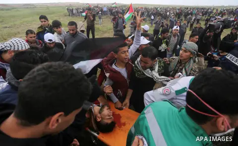 A wounded Palestinian is evacuated during clashes with Israeli security forces, during a tent city protest along the Israel border with Gaza, demanding the right to return to their homeland, east of Gaza City March 30, 2...